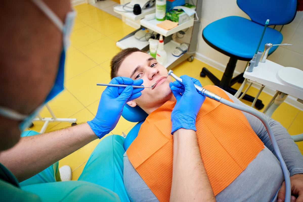 a man in a chair at the dentist, dental office, dental treatment