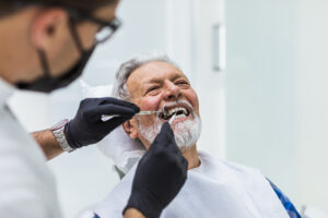 Older woman smiling confidently after receiving implant-supported overdentures
